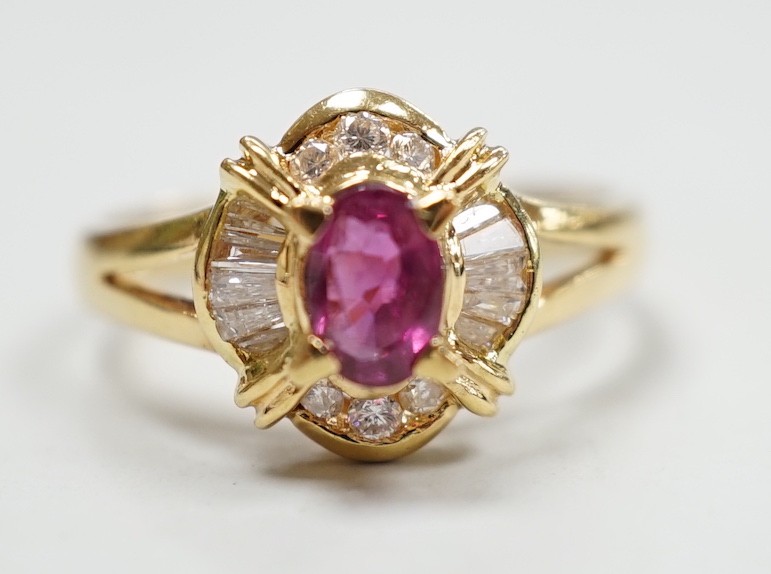 A modern 18ct gold, single stone ruby and trapeze and round cut diamond cluster set dress ring, size O, gross weight 4.7 grams.